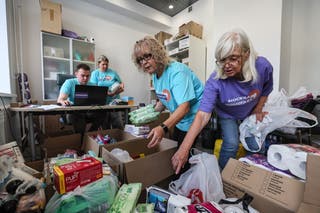 人道支援物資集積所でクルスク地域の住民に提供される人道支援物資を仕分けるボランティアたち